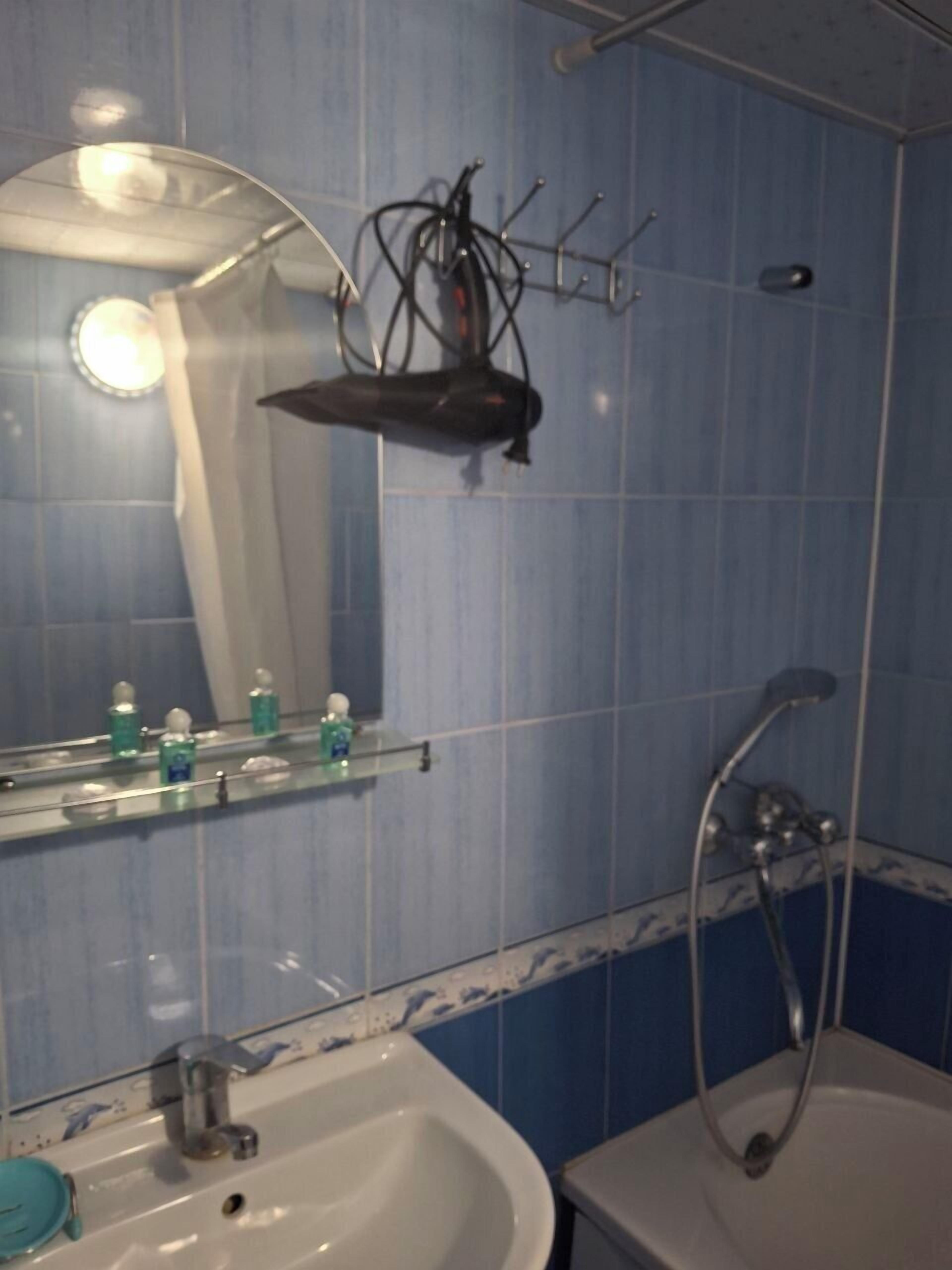 Un bagno con lavandino, specchio e doccia.