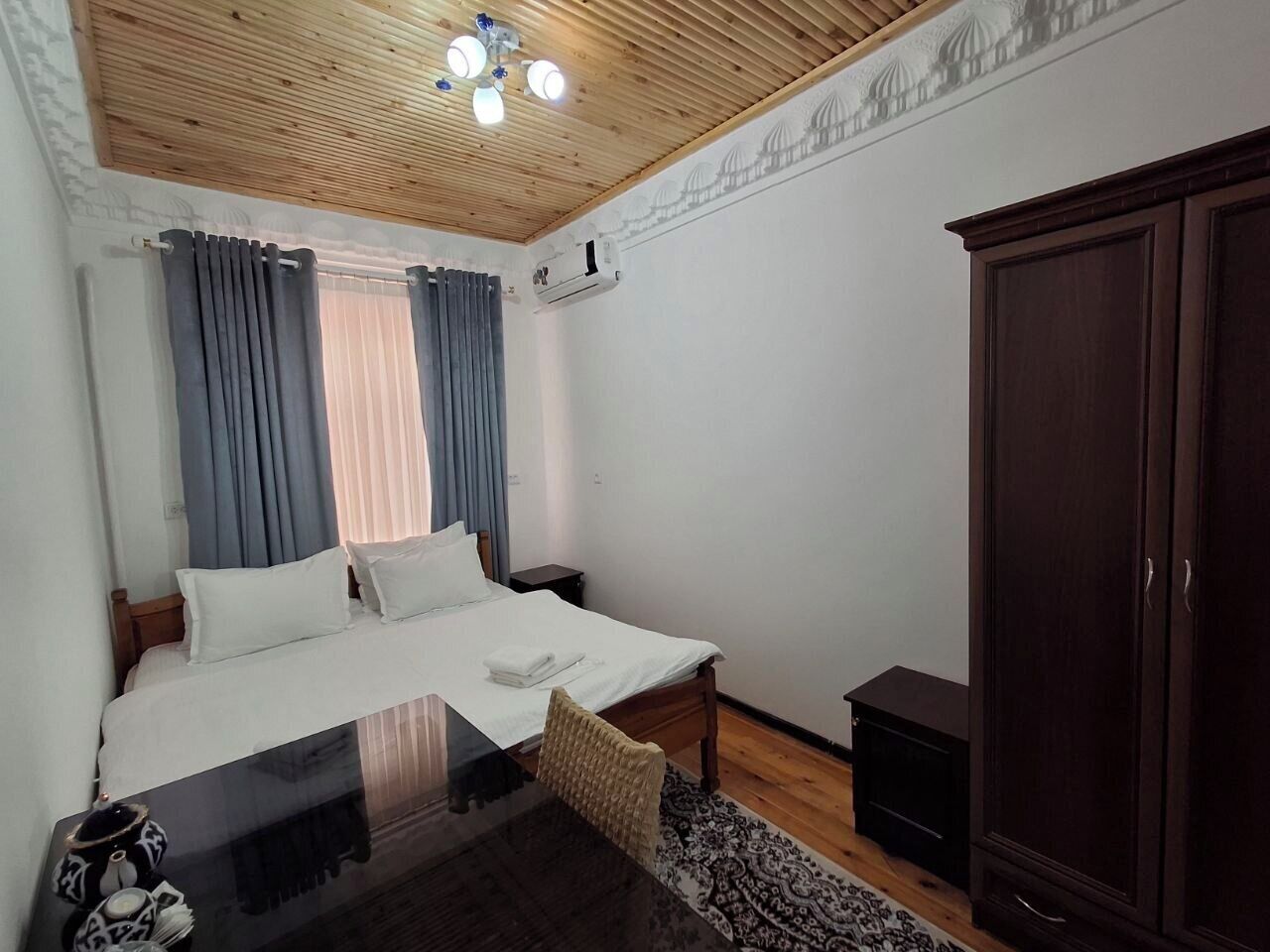 Un dormitorio con cama, mesitas de noche, armario y ventilador de techo.