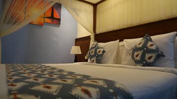 Quarto de hotel com cama, mesa de cabeceira, luminária e um quadro na parede.