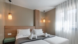 A double bed with white linens, two bedside tables, and a wooden headboard.
