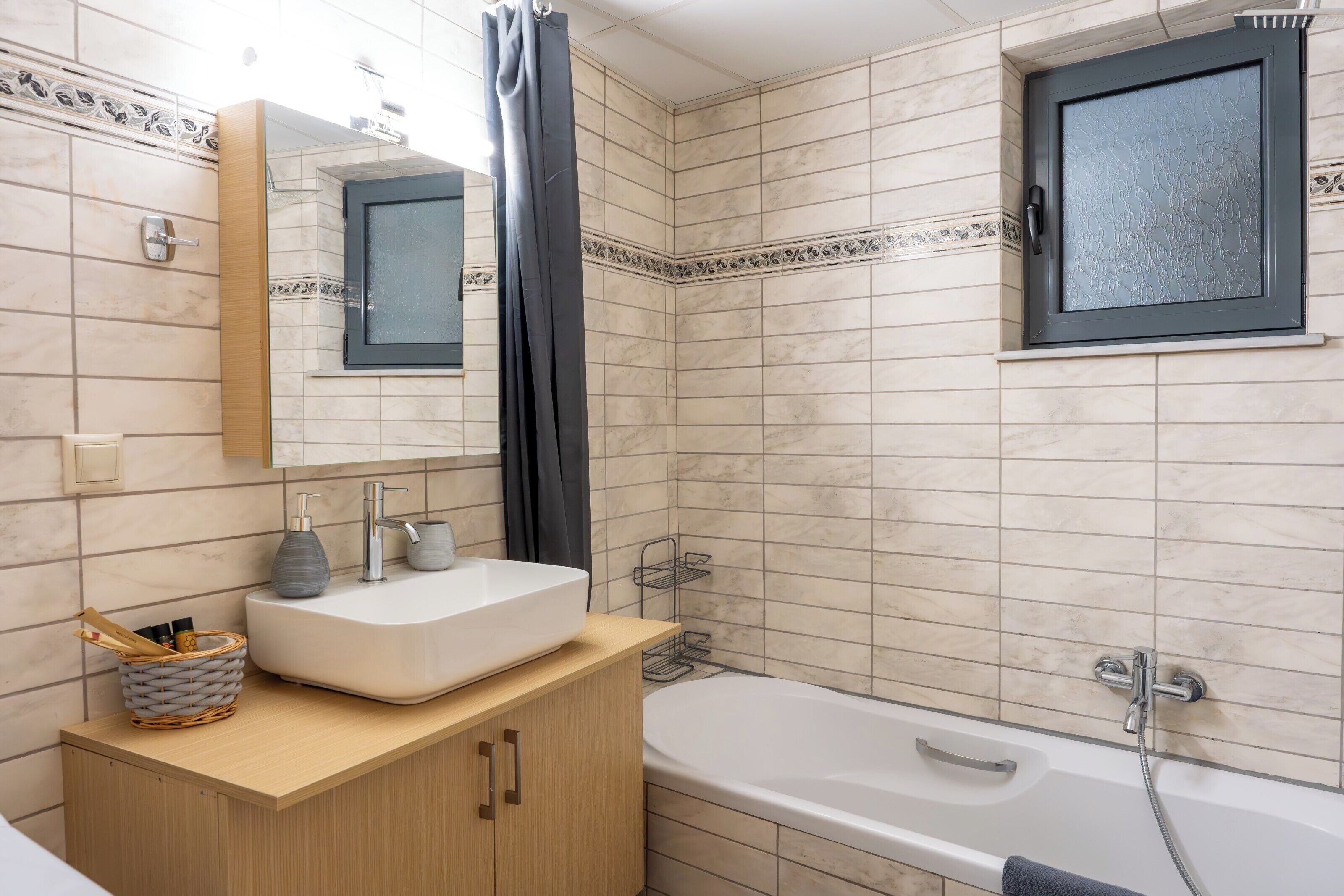 Une salle de bain avec une baignoire, un lavabo avec un miroir et un espace douche.