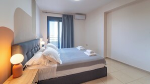 Une chambre à coucher moderne, avec un lit, une lampe de chevet et un appareil de climatisation.