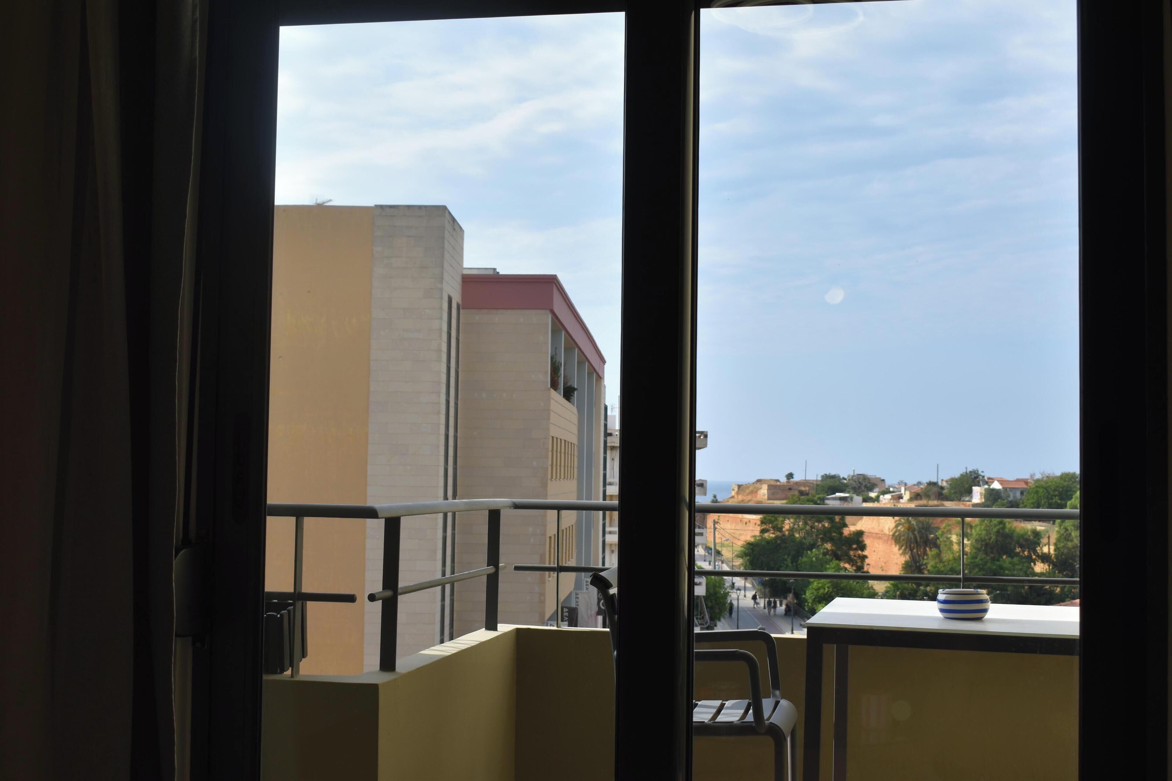 Un balcón con vistas a edificios y un cielo despejado.