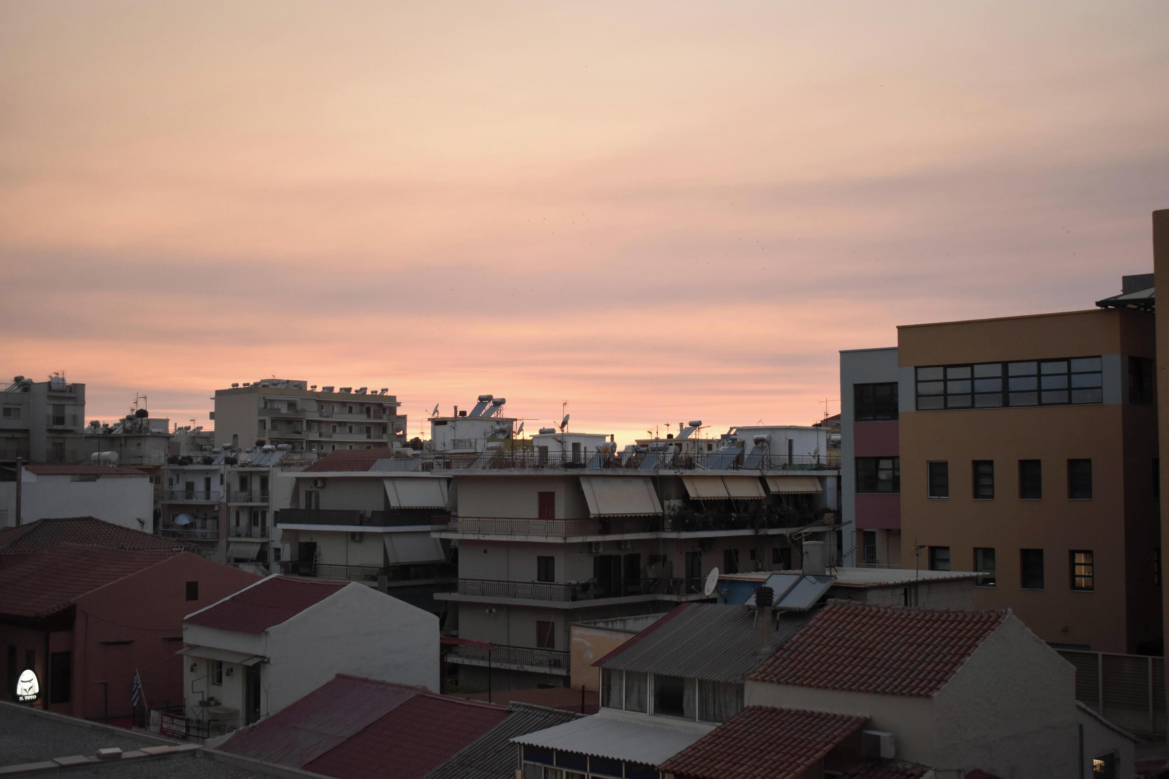 A residential area with multiple buildings, some with flat roofs and others with sloped roofs.