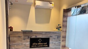 A reception desk with a marble floor, a ceiling fan, and an air conditioning unit. - Hotel Lavish Park (Mumbai)