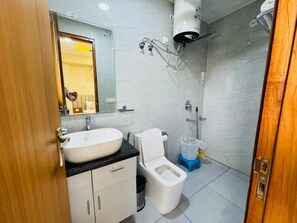 A modern bathroom with a sink, toilet, and shower. - Akshay Premium Suites (Gurugram)