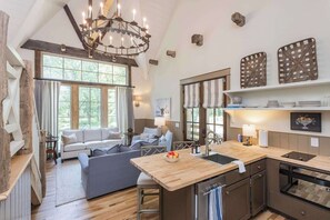 A cozy living area with a sofa, a dining table, and a kitchen with a wooden countertop and a built-in dishwasher.