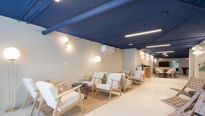 Ein modernes Interieur mit weißen Stühlen, einem runden Tisch und einer blauen Decke.