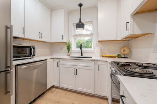 Charming cottage entrance with cozy curb appeal, nestled in a peaceful and green setting.