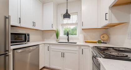 Charming cottage entrance with cozy curb appeal, nestled in a peaceful and green setting.