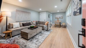 A modern living room with a sectional sofa, a coffee table, and a dining area with a small table and chairs.