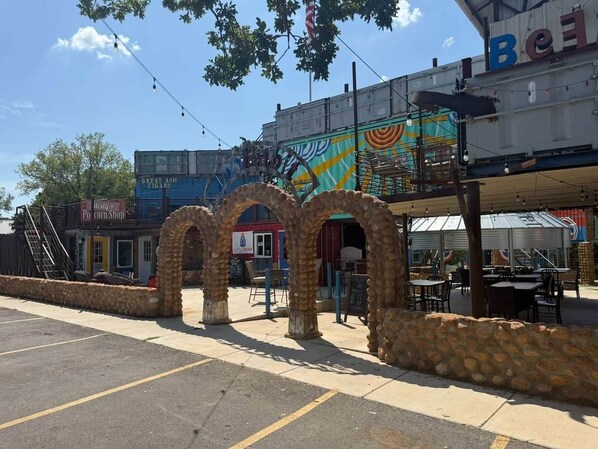 Un estacionamiento con un muro de piedra y un edificio con un mural colorido.
