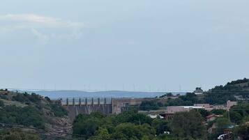 Un barrage doté de plusieurs déversoirs et un pont en arrière-plan.