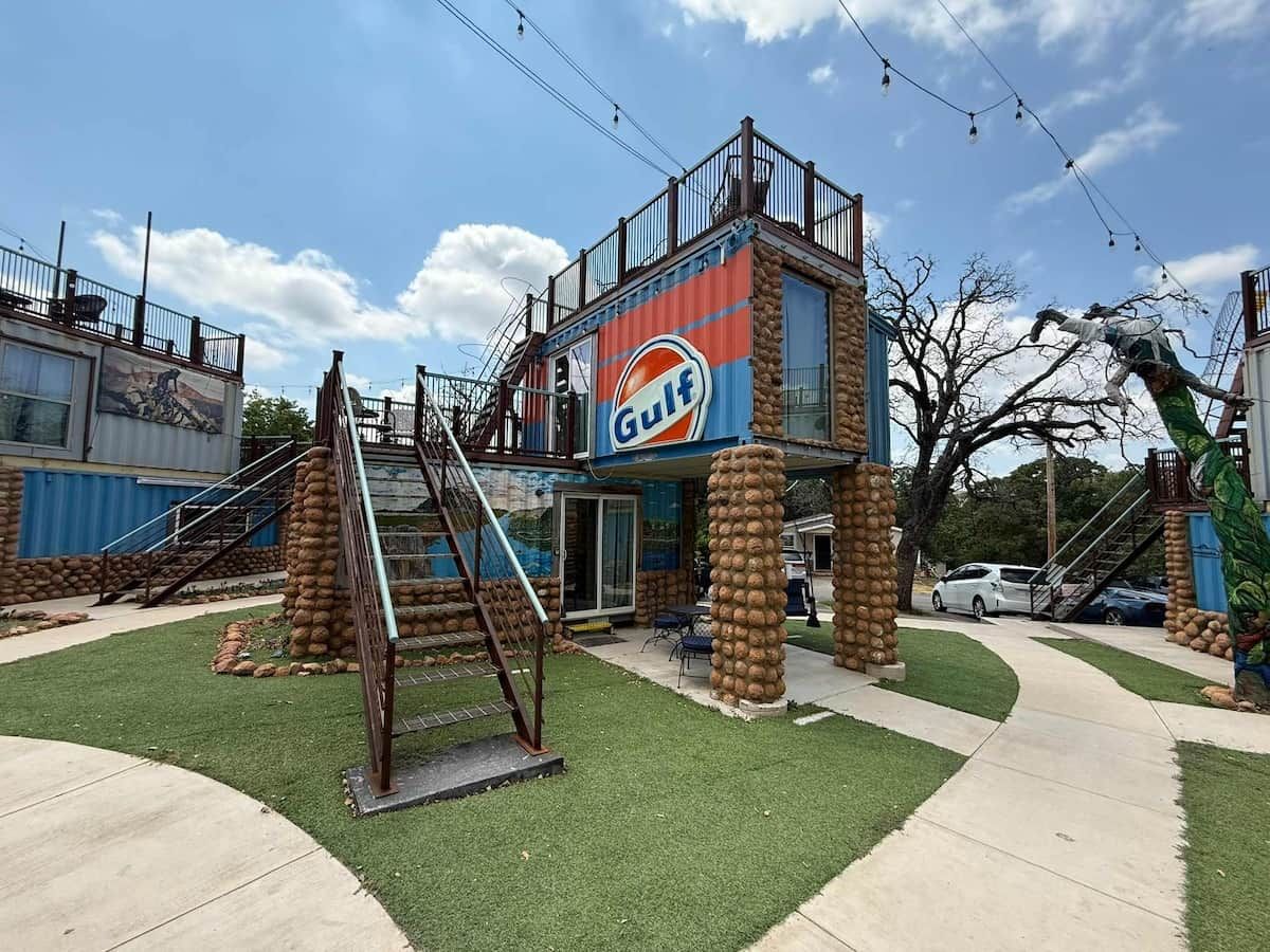 A building with a Gulf sign, a staircase, and a small outdoor area with grass.