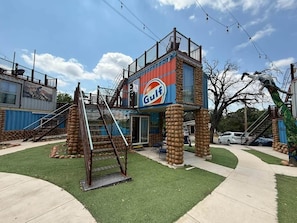 A building with a Gulf sign, a staircase, and a small outdoor area with grass.