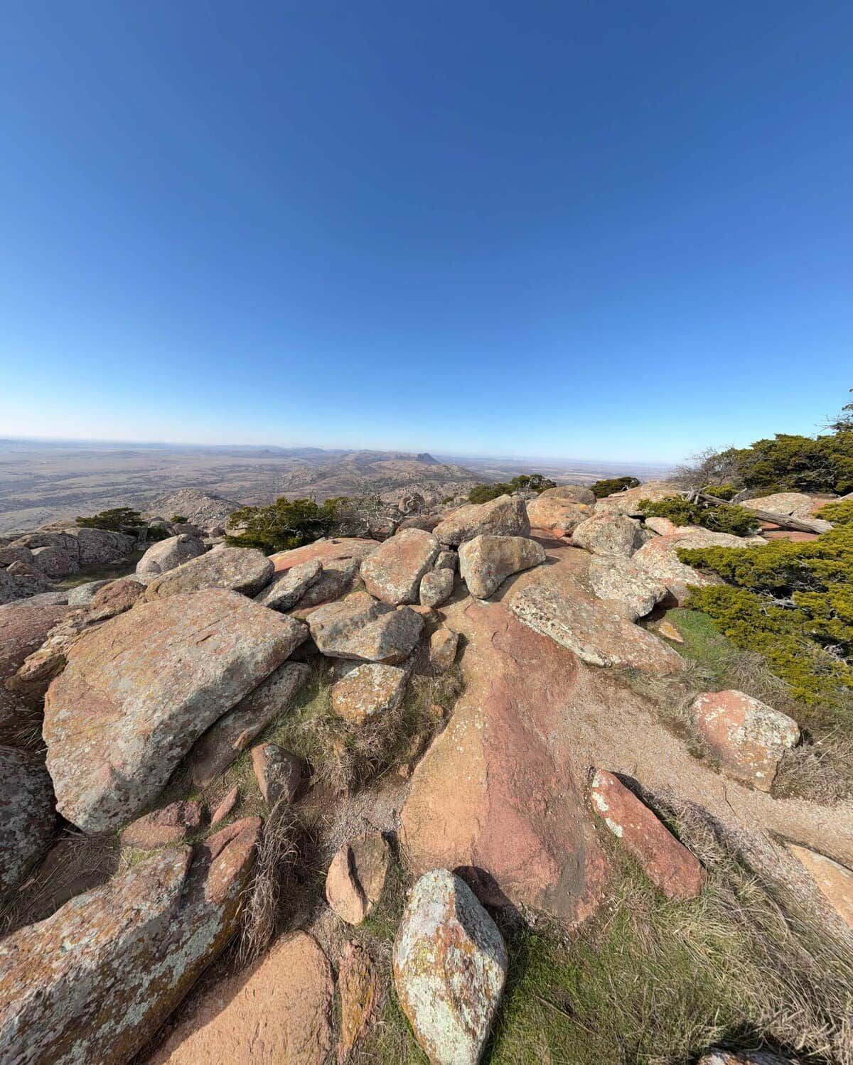 A rocky landscape with large boulders and sparse vegetation.