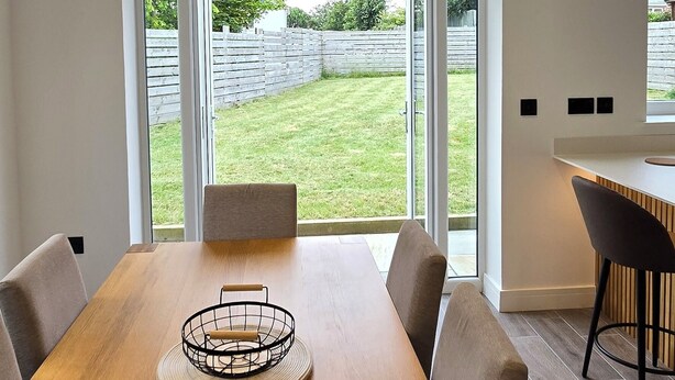 A modern kitchen with a wooden table, chairs, and a bar area.