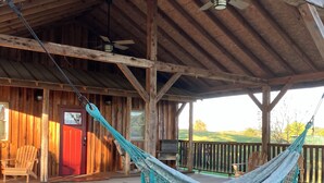 Eine Holzhütte mit Veranda, einer Hängematte und einer roter Tür.