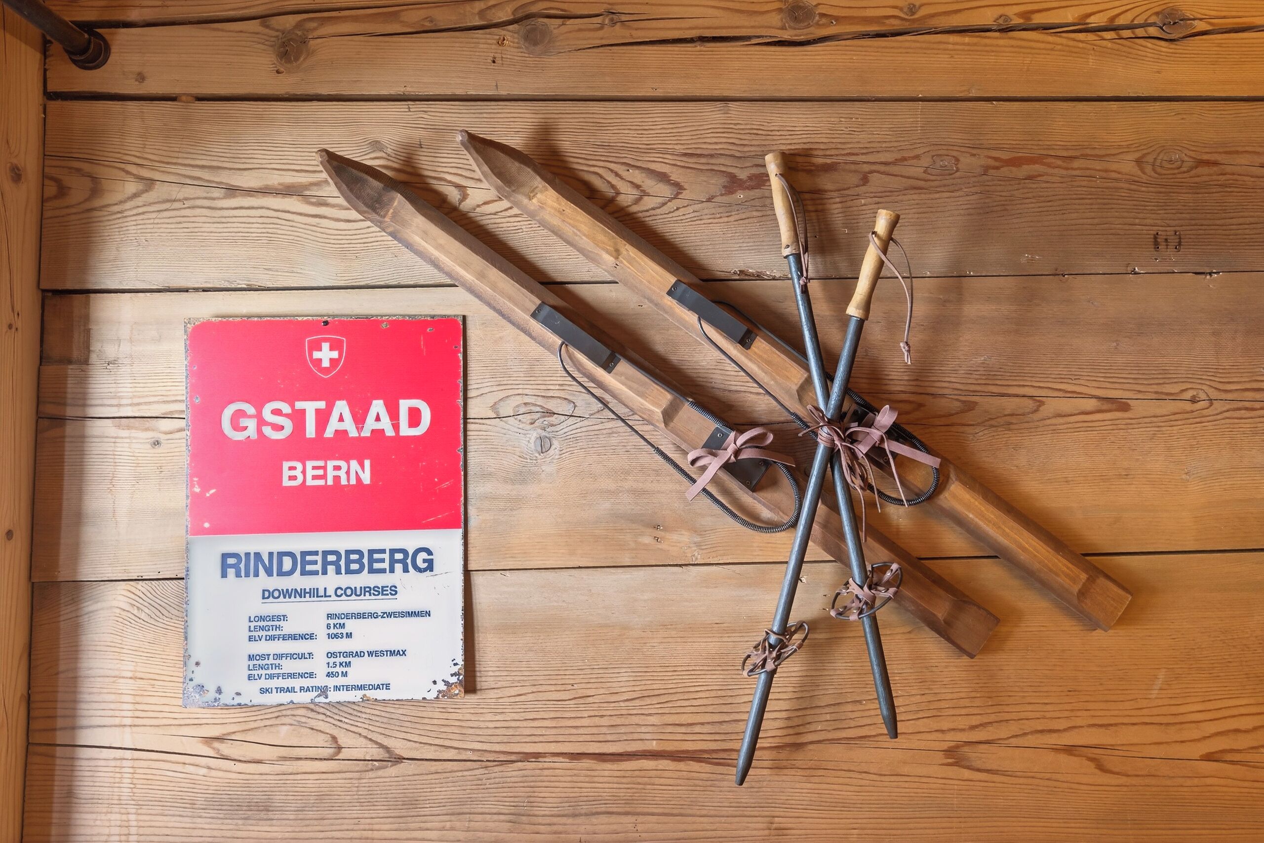 Un suelo de madera con esquíes y bastones de esquí dispuestos sobre él.