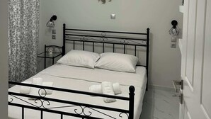 Ein Schlafzimmer mit einem Bett, einem Nachttisch, einer Wandlampe und einem Deckenventilator.