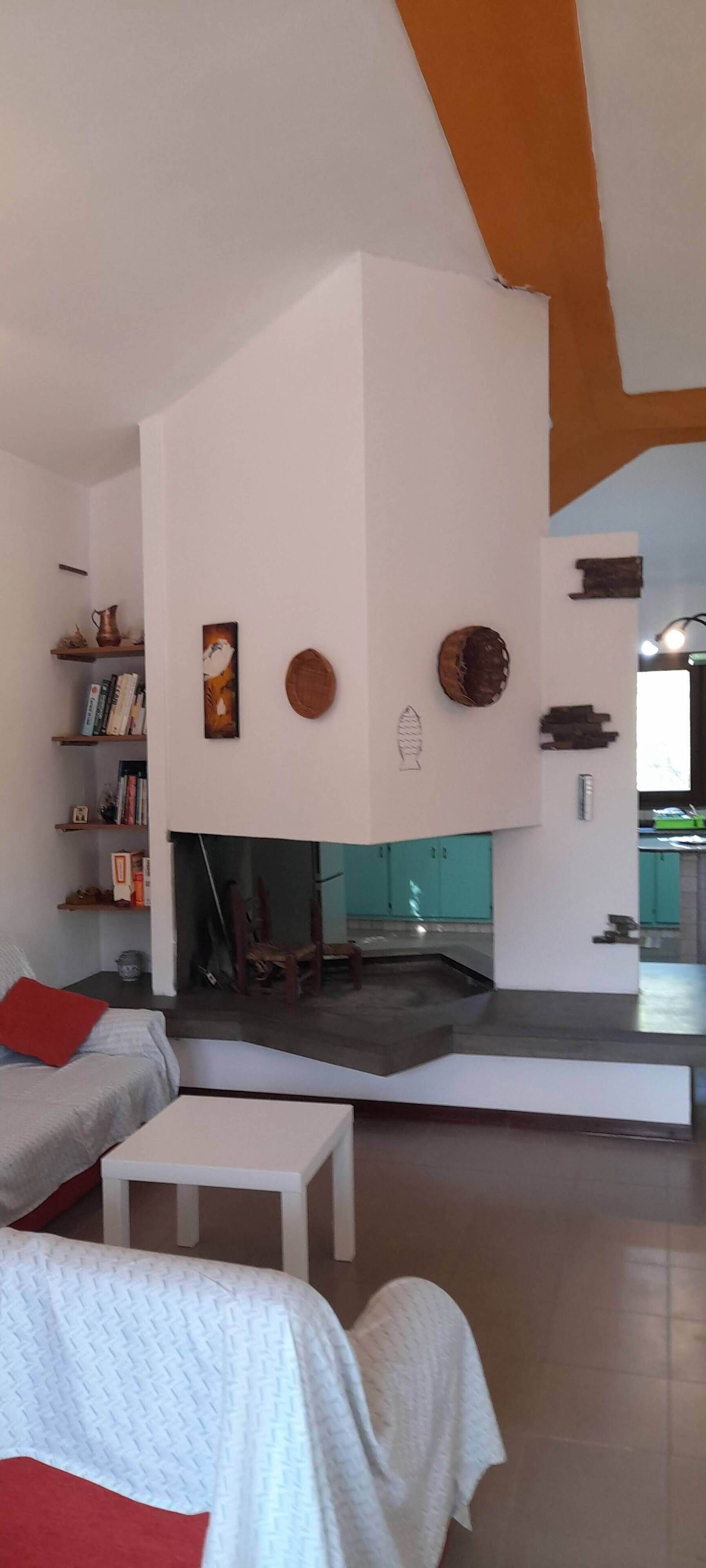 Una sala de estar moderna con chimenea, un sofá, una mesa de centro y una estantería.