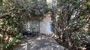 A stone building with a small porch, surrounded by dense foliage. - House in the green between sea and countryside (San Vero Milis)