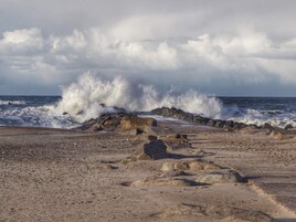 Una playa rocosa con olas rompiendo contra la orilla.