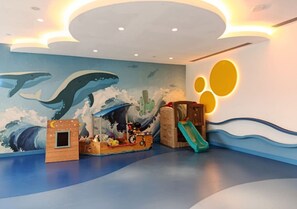 A children's play area with a mural of whales and a slide. - Art-Inspired 1 Bedroom in Wilton Terraces (Dubai)