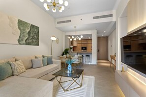 A modern living room with a sofa, coffee table, and a dining area with chairs and a table.