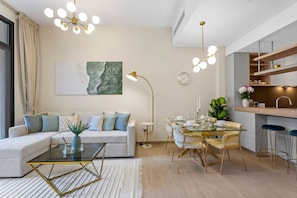 En moderne stue med sofa, sofabord og spiseplads med stole og et glastop bord.