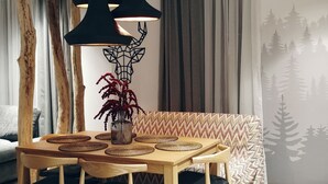 A dining area with a wooden table, black chairs, and a modern pendant light fixture.