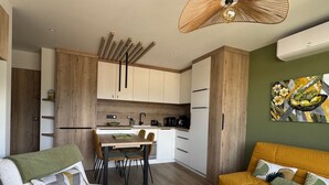 A compact living space with a kitchenette, a dining area, and a seating area with a sofa and a small table. - Stunning renovated T2, air conditioning, parking, balcony - City and mountain views (Aix-les-Bains)