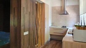 A modern kitchen with wooden cabinetry, a stainless steel range hood, and a countertop with a toaster. - Cozy apartment in the city center with AC & Wi-Fi (Tashkent)