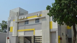 A modern building with a flat roof, large windows, and a covered entrance. - Hotel Vrindavan Palace (Giridih)