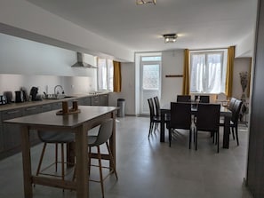 Una cocina moderna con comedor, un amplio ventanal y una puerta.