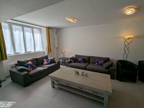 Uma sala de estar moderna com um conjunto de sofá, uma mesa de centro e um abajur.
