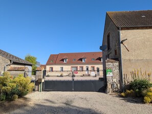 A gated entrance to a building with a tiled roof, a security camera, and a sign indicating a private property.