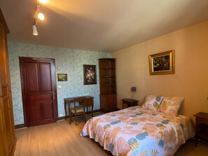 A bedroom with a bed, a desk, a chair, a bookshelf, and a door. - Spacious Family Home with Pool and Parking in Saint-Gaultier (Saint-Gaultier)
