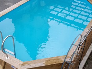 A rectangular swimming pool with clear blue water, surrounded by a wooden deck and metal ladder. - Spacious Family Home with Pool and Parking in Saint-Gaultier (Saint-Gaultier)