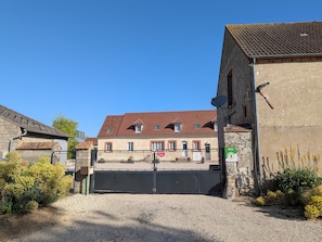 A gated entrance to a building with a tiled roof, a security camera, and a sign indicating a private property.