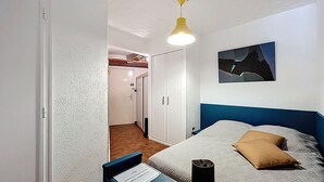 A bedroom with a bed, a bedside table, a lamp, and a wall-mounted picture. - Bright studio 4 pers, near beach with Wi-Fi (Mauguio)