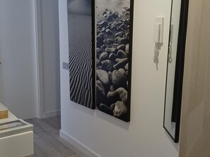 Een gang met twee aan de muur bevestigde kunstwerken met natuurlijke structuren.