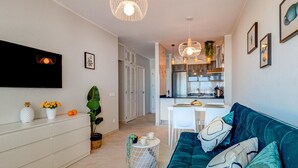 Un salon moderne avec un canapé, une table basse et un téléviseur fixé au mur.