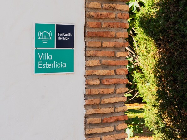 Une enseigne pour la Villa Esterlicia, avec un fond vert et des lettres blanches.