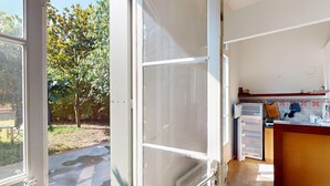 A kitchen with a view of a garden through an open door. - House in Vic-la-Gardiole, 2 pers, Terrace, Close to Beach (Vic-la-Gardiole)