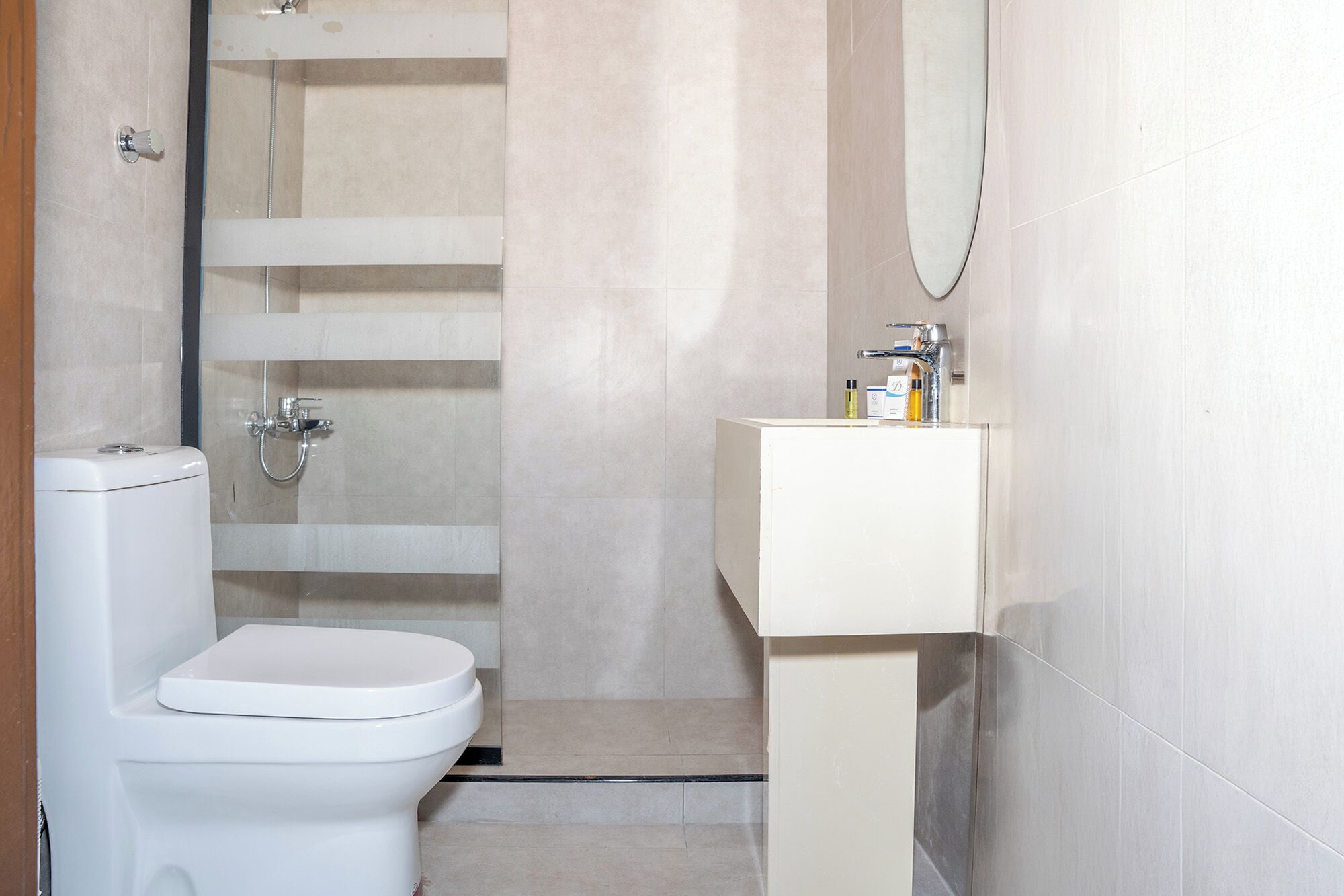 A bathroom with a toilet, a shower, and a sink.