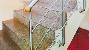 A staircase with metal handrails and a red brick wall.