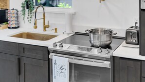 Une cuisine moderne équipée d’une cuisinière en acier inoxydable, d’un évier et d’un grille-pain.