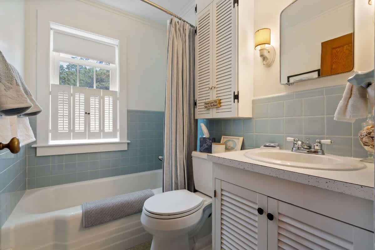 A bathroom with a bathtub, toilet, and sink.
