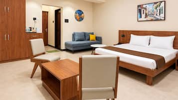 Una habitación de hotel con cama, sofá, escritorio y silla.